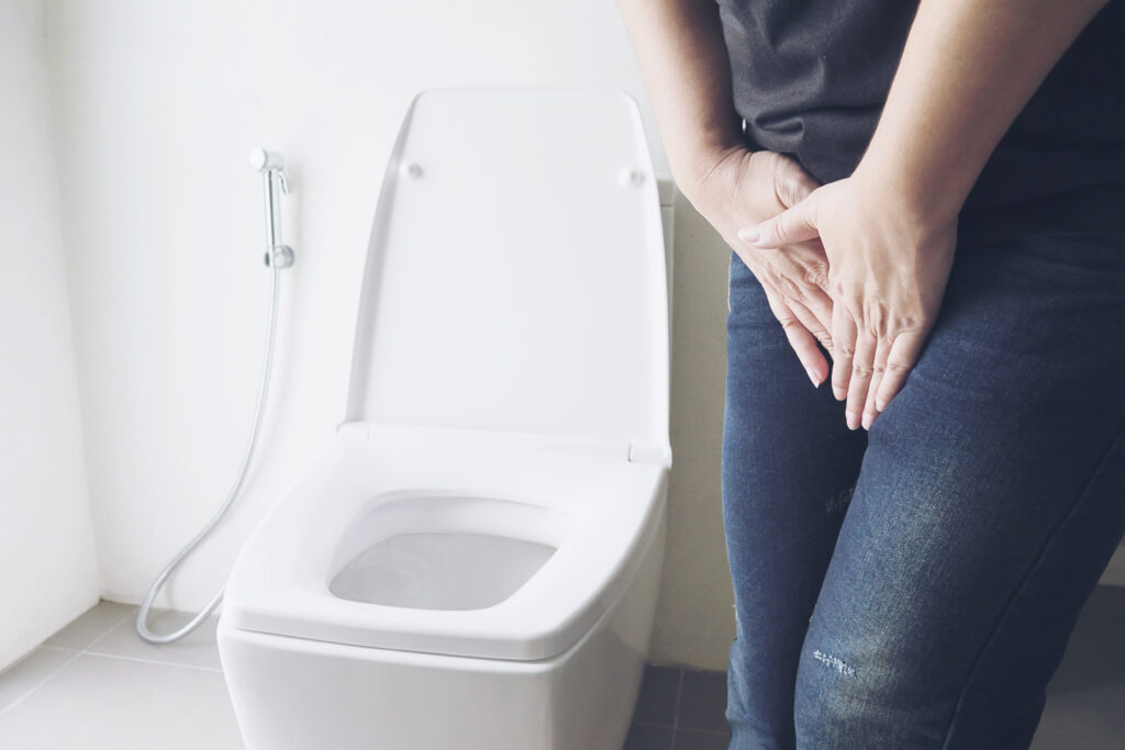 Freepik imagem: Mulher segurando a mão perto do vaso sanitário - conceito de problema de saúde infecção urinária.