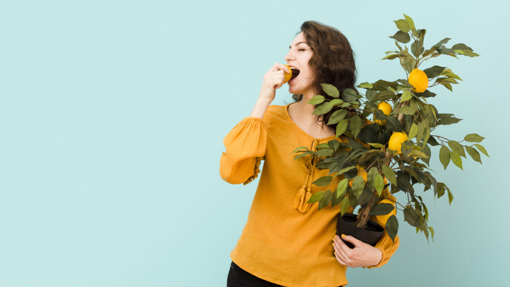 Freepik imagem mulher jovem segurando um vaso de frutífera.